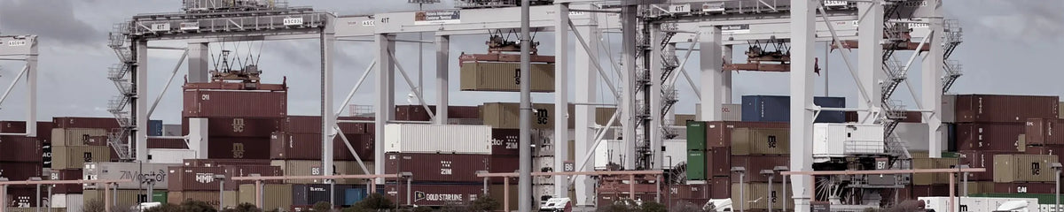 Container cranes and stacked shipping containers at a port terminal