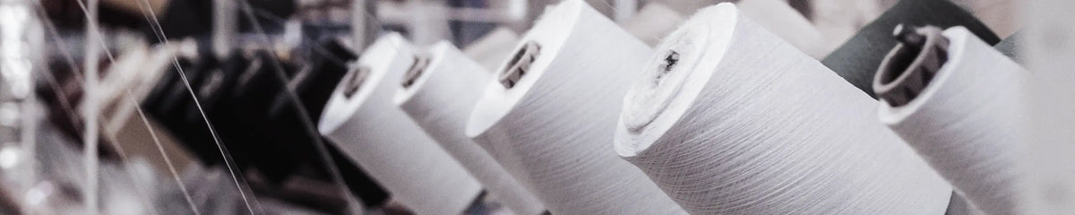 Yarn spools on a spinning frame in a textile manufacturing facility